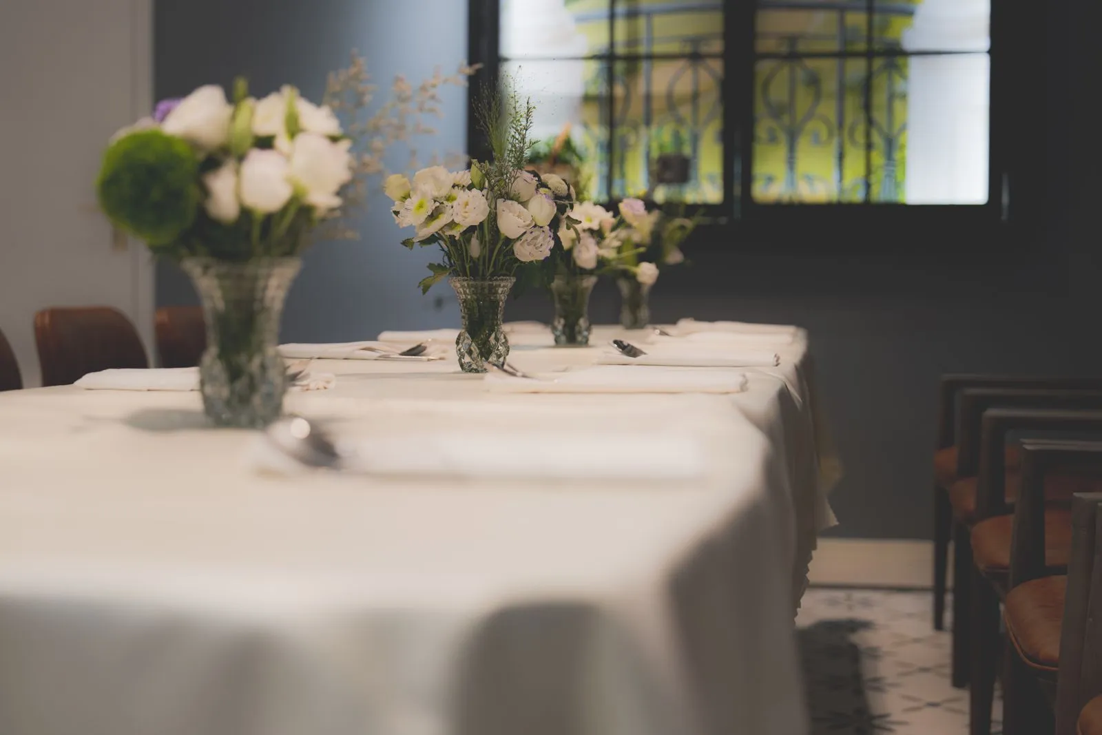 Restaurant-style dining room set with linens and fresh flowers